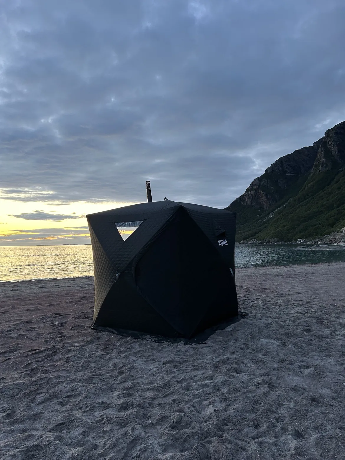 Mobilt badstutelt på sandstranda i kveldslys med fjell og hav – leie badstue i Bodø